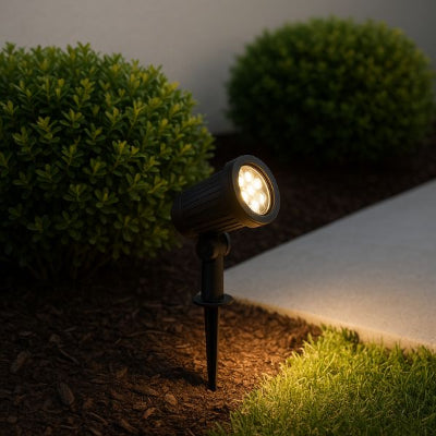 spot exterieur solaire illuminant un massif floral près d’une allée