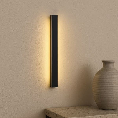 applique exterieur fixée sur le mur clair à côté d'un vase posé sur un meuble en marbre