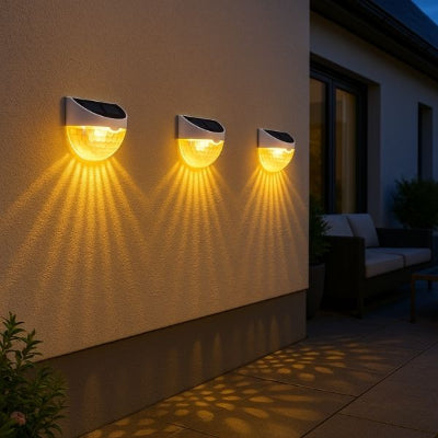 applique exterieur solaire sur mur de maison avec projection de lumière chaude, salon de jardin devant baie vitrée et plantes