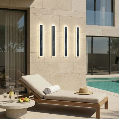 applique exterieur solaire sur mur de maison contemporaine ave piscine, chaise longue avec chapeau et serviette, table basse, grandes baies vitrées