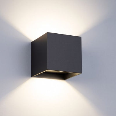 Applique murale extérieur cube noir diffusant lumière LED moderne.