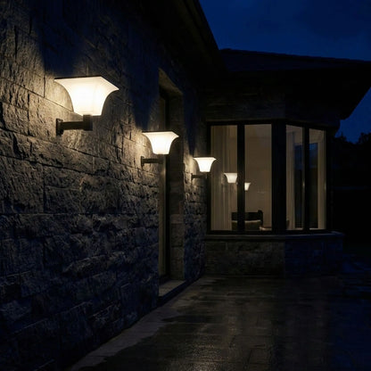 appliques exterieures solaires sur mur en pierres la nuit avec grandes baies vitrées