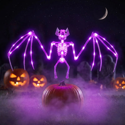Chauve souris Halloween solaire allumée la nuit près de citrouilles éclairées