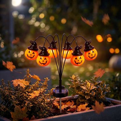 Citrouille lumineuse solaire à 6 têtes plantée dans une jardinière, feuilles d'automne, de nuit