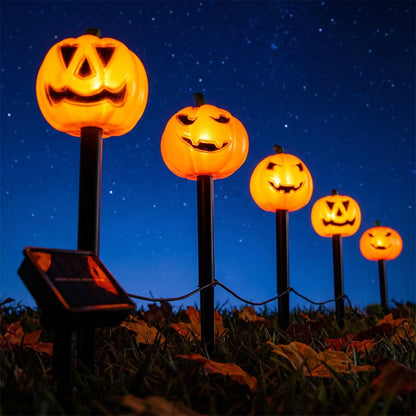 Rangée de decorations citrouille halloween à piquets solaires allumées sous un ciel étoilé