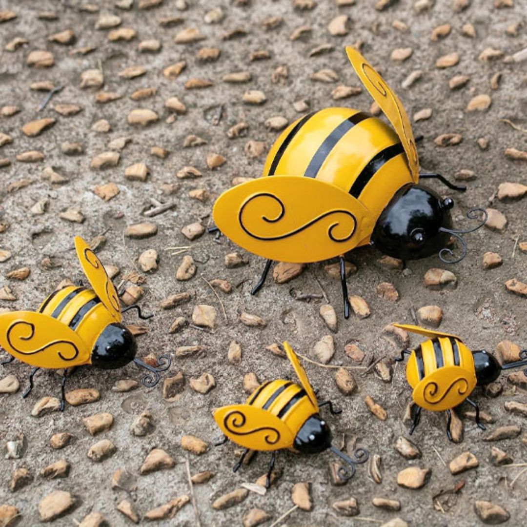 Décoration jardin extérieur famille d’abeilles métal colorées sur un sol gravillonné