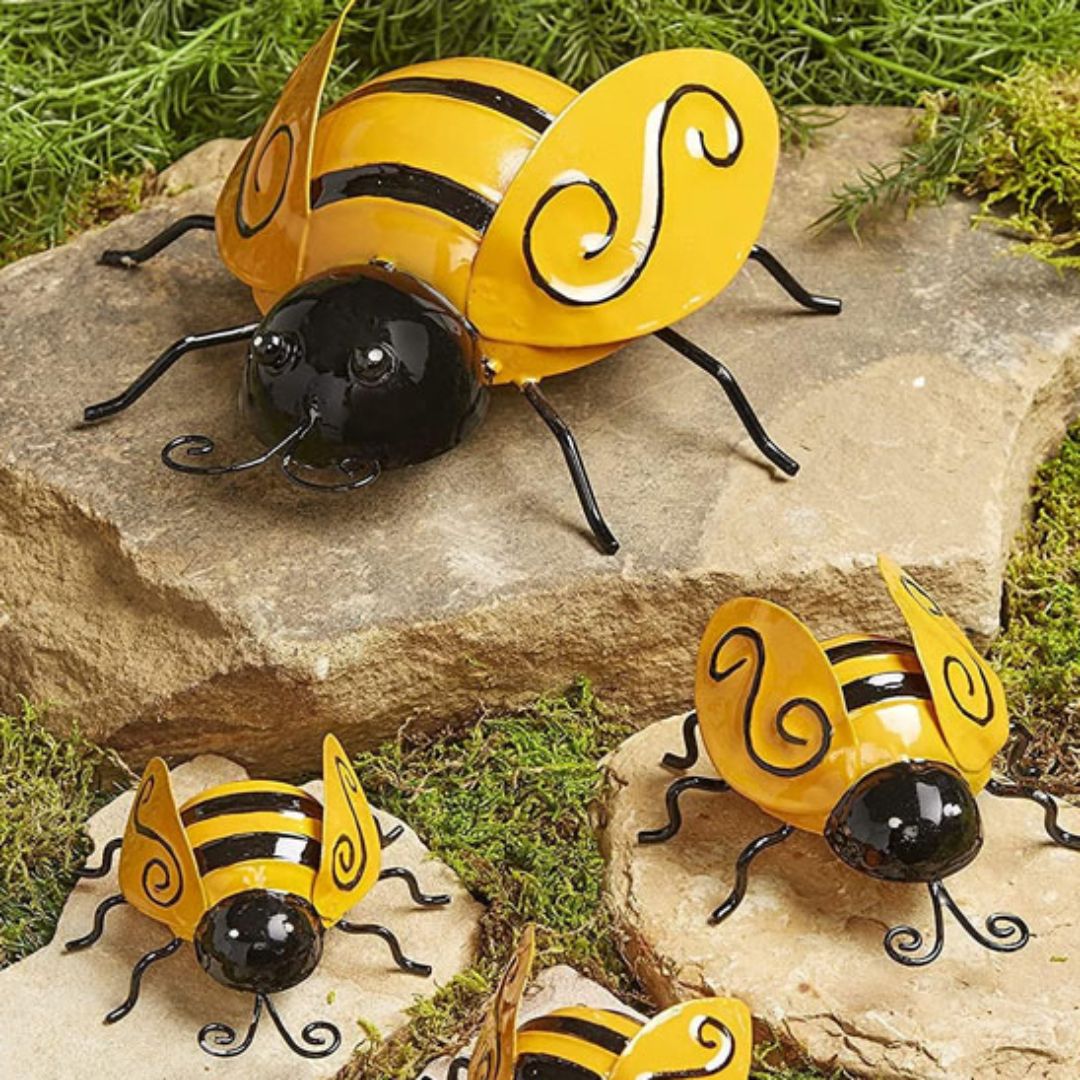Décoration jardin extérieur abeille jaune et noire posée sur des pierres, déco métal originale