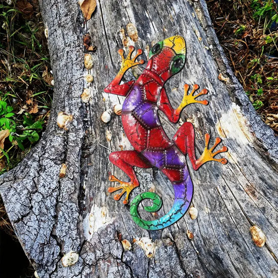 Lézard en métal rouge et violet posé sur une souche de bois, décoration extérieure colorée et vive
