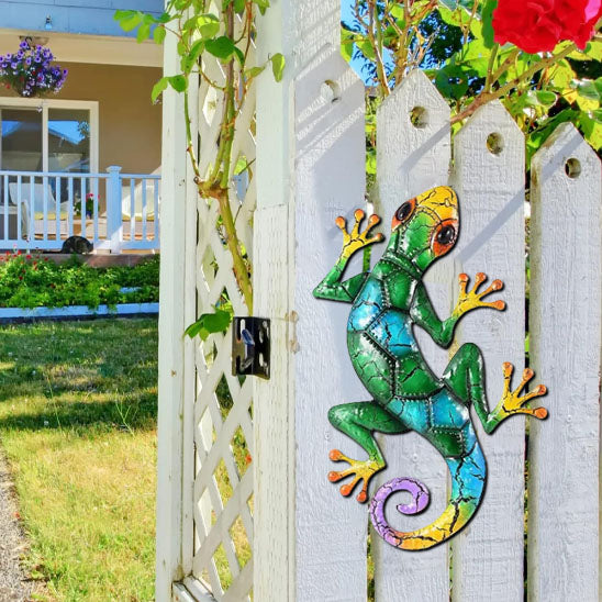 Lézard décoratif vert et bleu en métal fixé sur un portail en bois blanc, deco jardin originale