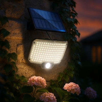 Éclairage extérieur solaire avec détecteur illuminant un mur en pierre au jardin pendant la nuit