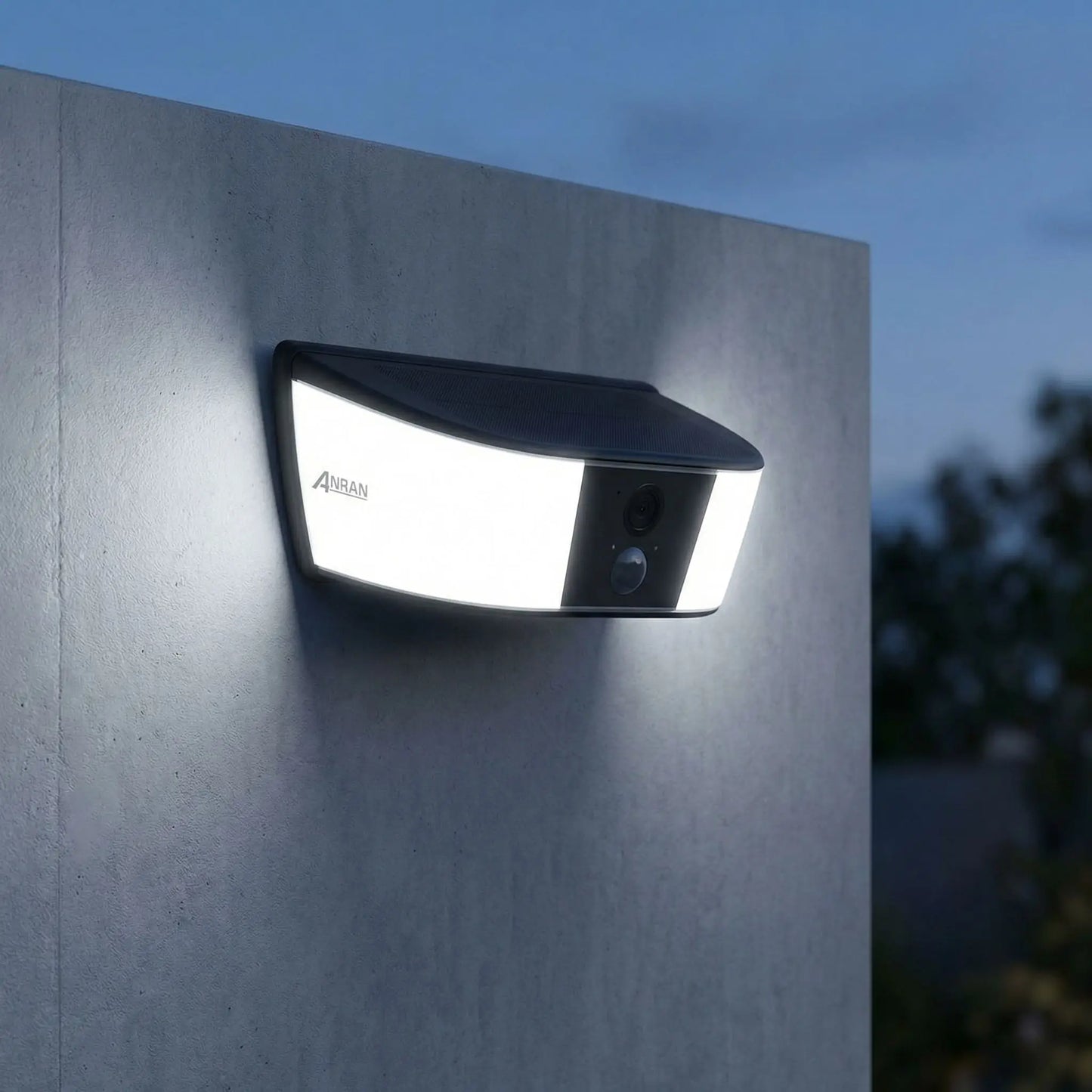 eclairage exterieur solaire avec detecteur blanc froid sur mur gris et arbres en second plan