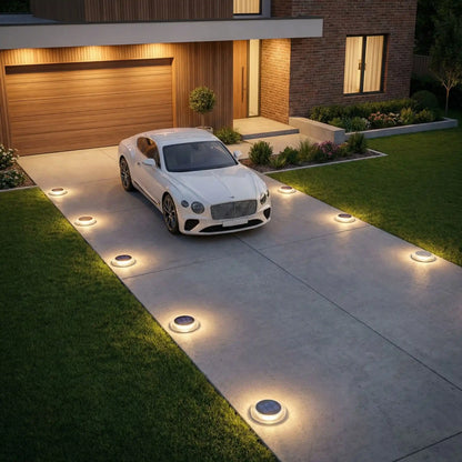 Eclairage sol exterieur solaire LED installé dans allée de garage avec lampes rondes étanches IP68 résistantes 5 tonnes pour jardin maison moderne