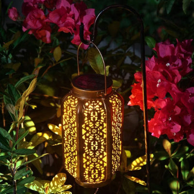 eclairage solaire exterieur en métal suspendue parmi des fleurs, idéale pour terrasse ou balcon