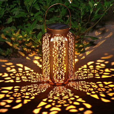 eclairage solaire exterieur en métal ajouré diffusant un motif lumineux décoratif au sol