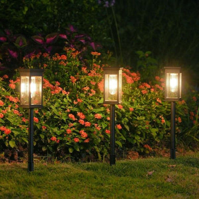 Éclairage solaire extérieur intégré dans un massif de fleurs pour créer une ambiance douce.