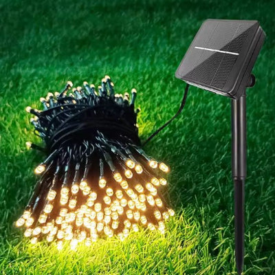 Guirlande exterieur solaire posée dans le jardin enroulée avec le capteur solaire