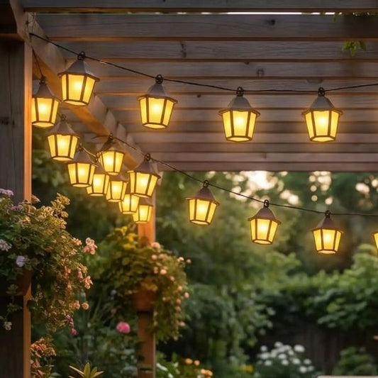 Guirlande solaire lanternes blanc chaud suspendue sous pergola en bois dans jardin chaleureux