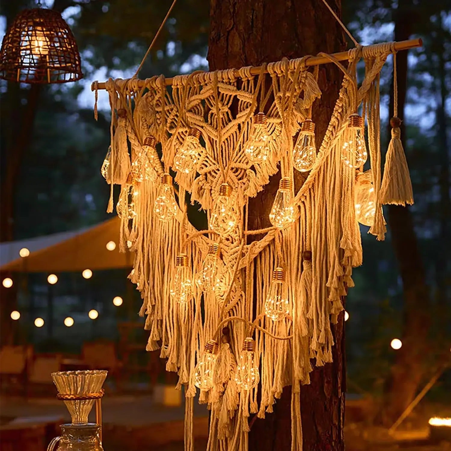 guirlande solaire blanc chaud accrochée à une décoration sur un arbre à l'extérieur