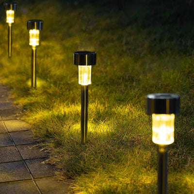 Lampe solaire extérieur led alignées éclairant une allée de jardin au crépuscule.