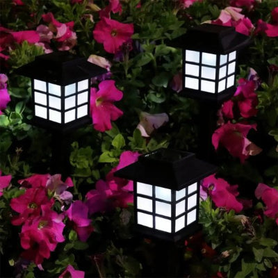 Lampe solaire extérieur Ignis placée parmi des fleurs colorées pour illuminer le jardin.