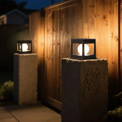 Lampe solaire extérieur carrée allumée posée sur piliers devant maison