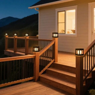 Terrasse en bois décorée avec lampe solaire extérieur carrée allumée design sur rambarde devant maison