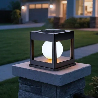 Lampe solaire extérieur carrée posée sur un pilier devant maison.