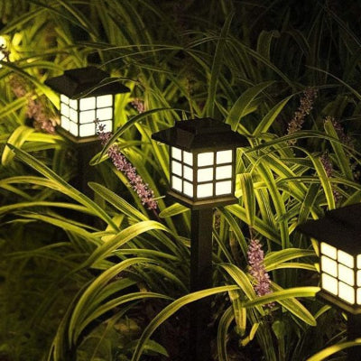 Lampe solaire extérieur éclairant un massif d’herbes, économie d'énergie