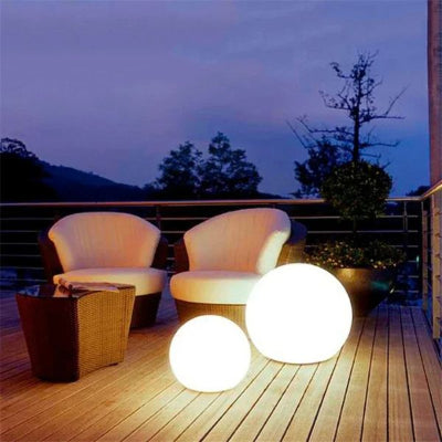 Deux lampe solaire extérieur boules blanches éclairent une terrasse cosy.