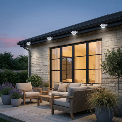 lampe solaire gouttiere installée sur maison en pierre de taille avec grande baie vitrée, salon de jardin et plantes dans pots