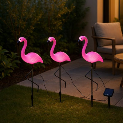 lampes jardins solaires en forme de flamants roses alignées sur une pelouse au crépuscule
