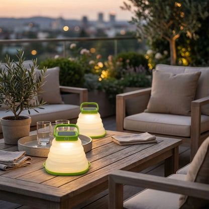 lanterne exterieur sur table basse avec plateau et deux verres, un olivier en pot et un salon de jardin sur terrasse floutée en arrière plan