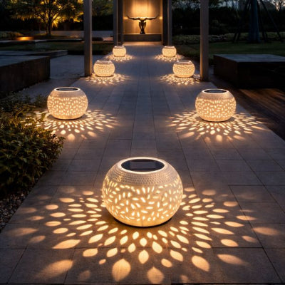 lanterne solaire couleur blanche bordant une allée dans un jardin au crépuscule