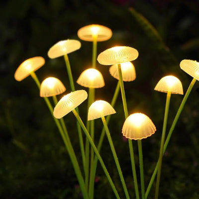 solaire lampe allumée plantée dans un massif de plantes vertes